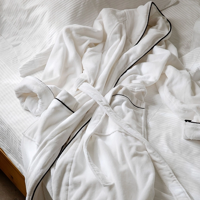 white luxury robe laid on a hotel bed