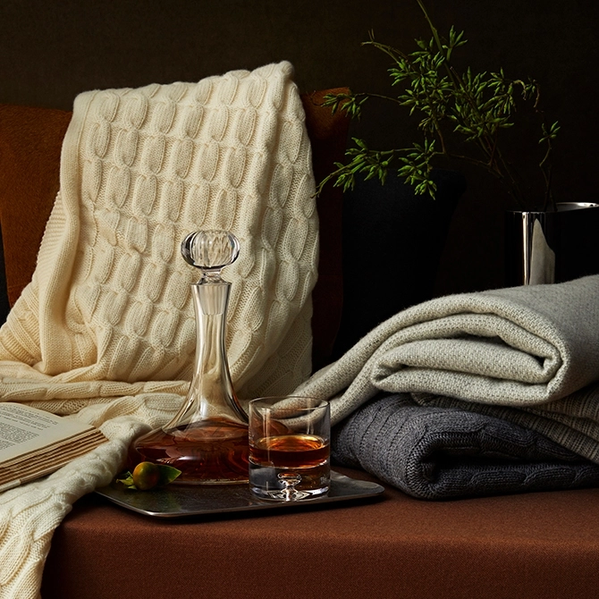 elegant knitted throws arranged on a leather chair